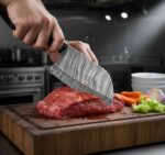 Monarch Cutlery Mini Cleaver Boning Knife trimming fresh meat on a wooden cutting board.
